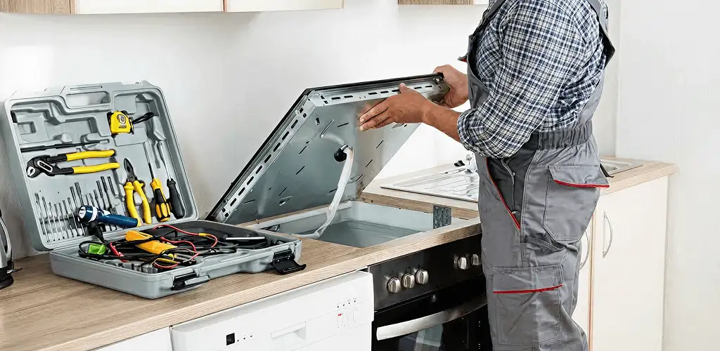 Handyman repairing a cooktop and checking wiring connections in St Paul, MN
