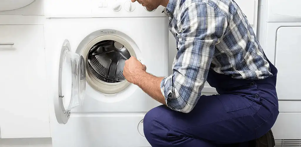 Handyman inspecting a dryer drum and internal parts for repair in St Paul, MN