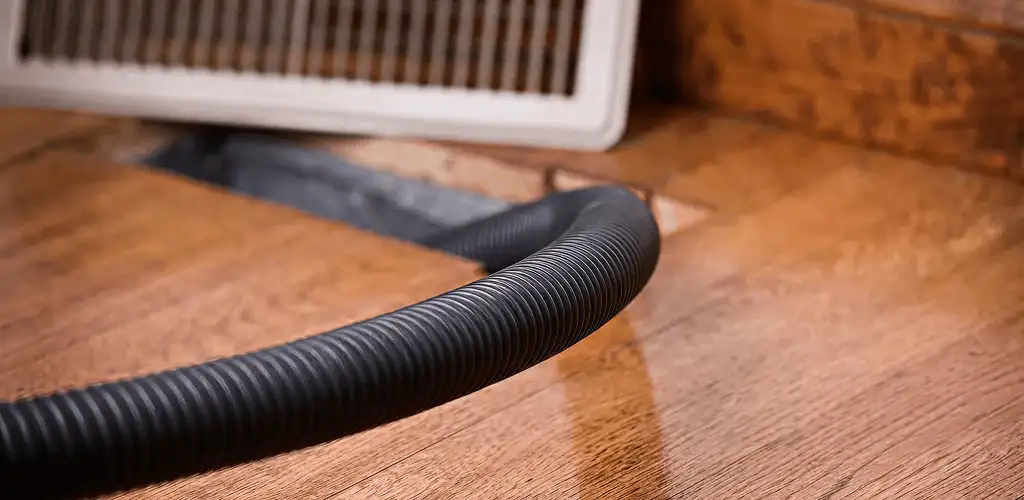 Air duct cleaning hose inserted into a floor vent for ductwork cleaning in St Paul, MN